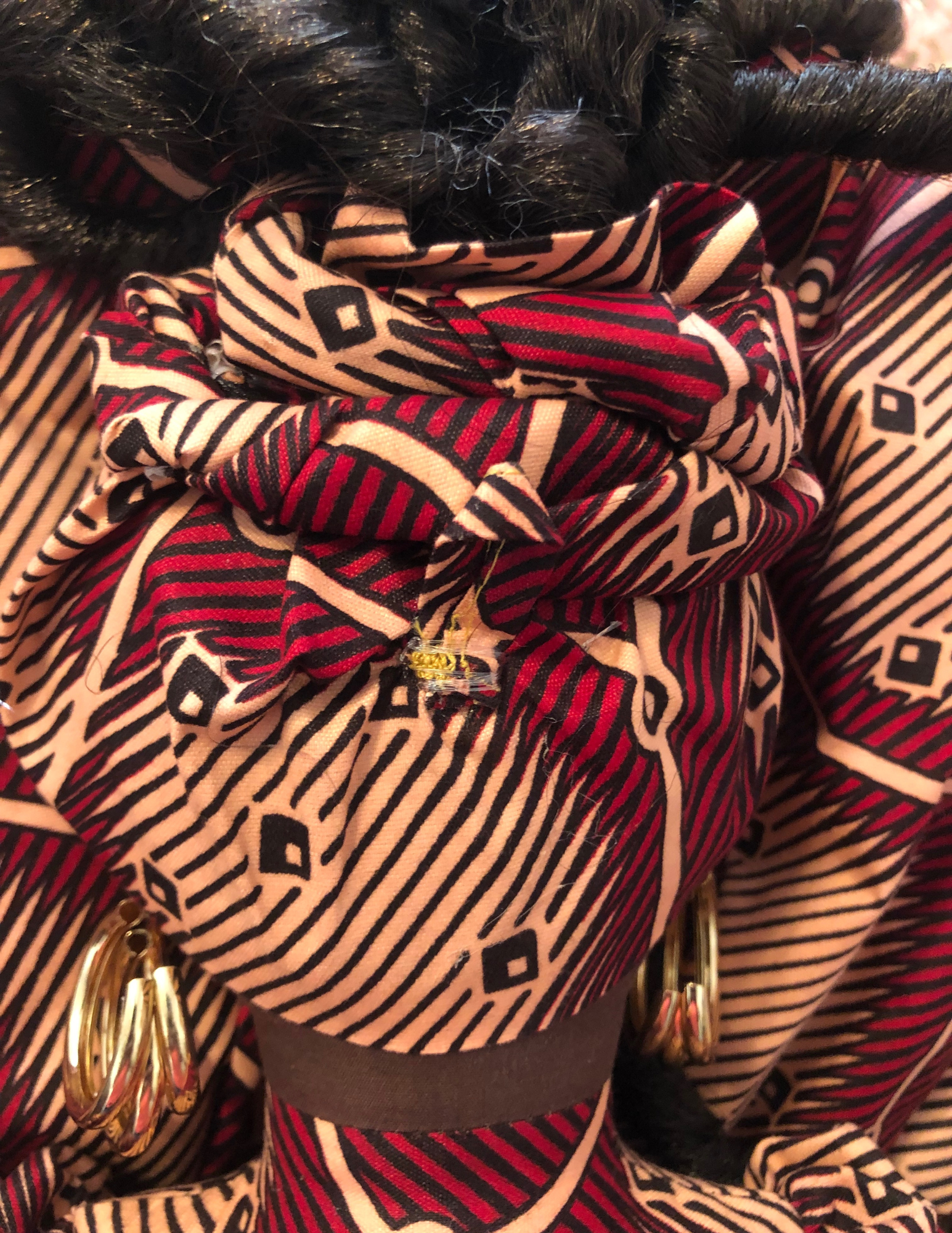 Handmade plastic bag holder doll Anaiah in African print dress with braided hairstyle and cowrie shell details